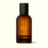 Amber glass Aesop Above Us, Steorra Eau de Parfum bottle with black cap on a white background.